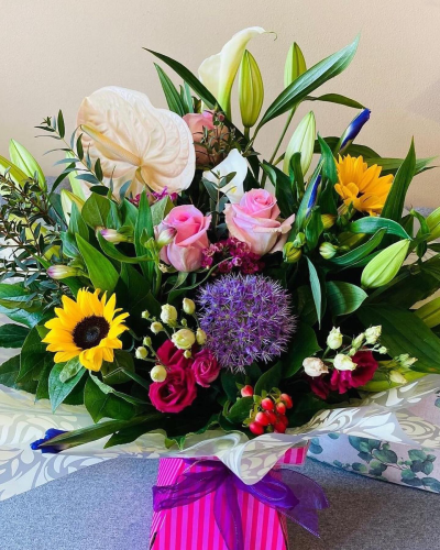 Bright Ideas - Beautiful Sunflowers and a peppering of other summer flowers and foliage. Tied in water and presented in a stylish bag. An amazing bouquet full of joy and delight ready to display and enjoy.